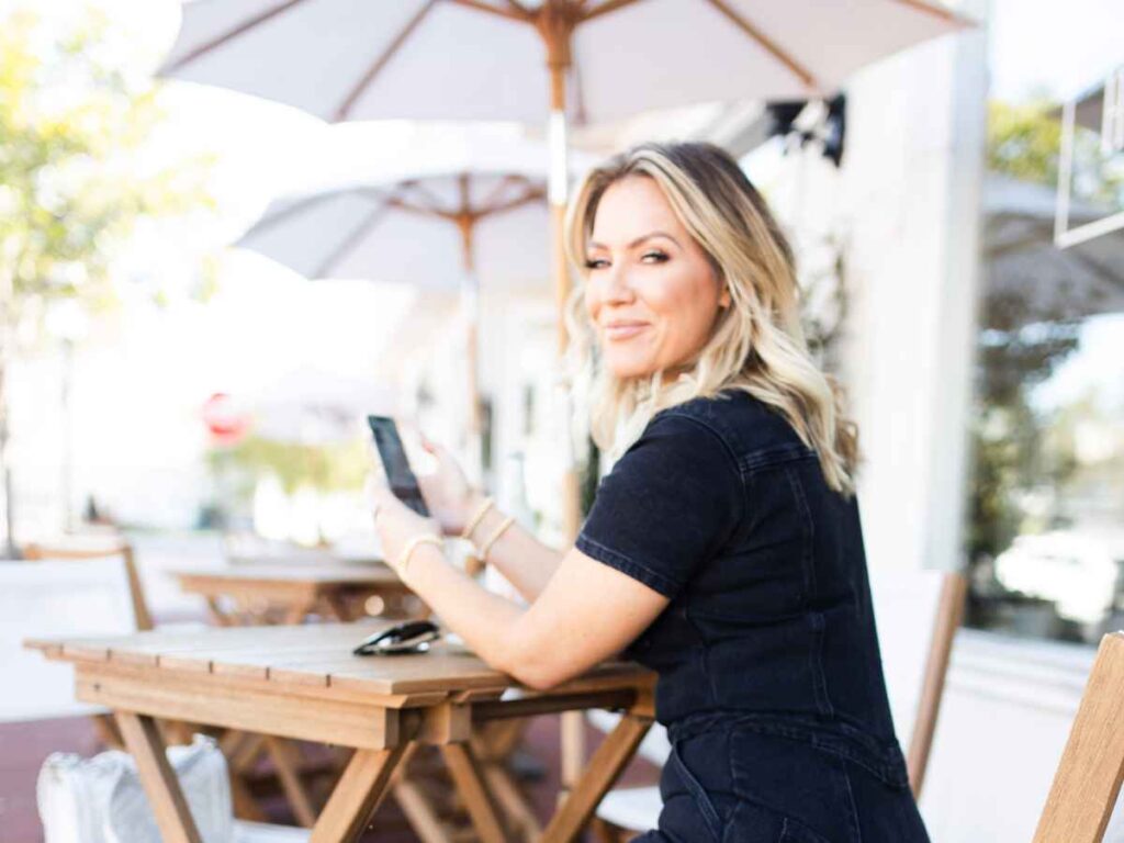 Cayla Craft, marketing and brand coach and founder of the Crafted Entrepreneur, using her smartphone to post updates to her social media accounts.