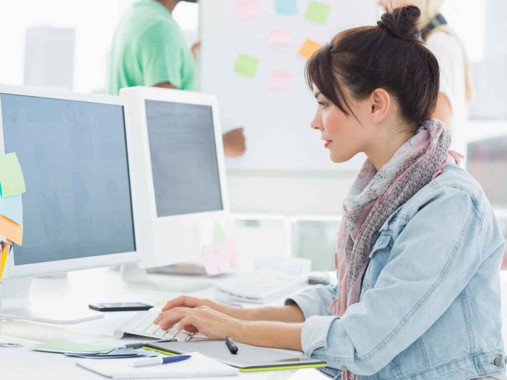 Young woman working at her computer to develop a content marketing plan for her art business